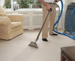 Carpet cleaning professional removing dirt and stains with a hot-water extraction tool in a home, Worcester, MA.
