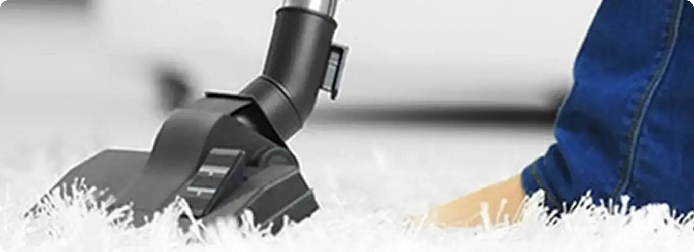 Close-up of a professional vacuuming a white carpet in Auburn.