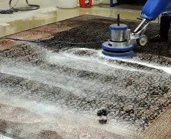 Professional rug cleaning with a rotary floor machine and shampoo foam, deep-cleaning an area rug, in Worcester, MA.